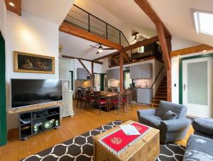 a living room with a large television and a dining room at Quellhuette Dachbodn in Weichselboden