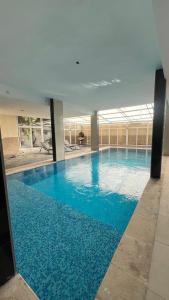 una grande piscina con acqua blu in un edificio di Tetra Tree Hotel 1 a Wadi Musa