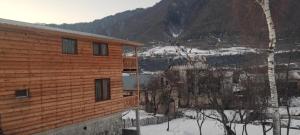 a wooden building in the snow next to a mountain at Ioane's Chalet in Mestia +12 photos
