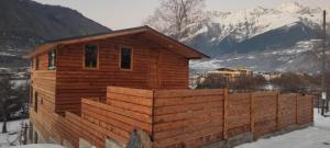 a wooden cabin with a fence in the snow at Ioane's Chalet in Mestia