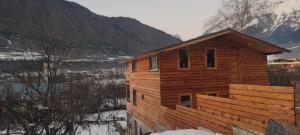 a wooden cabin with a mountain in the background at Ioane's Chalet in Mestia