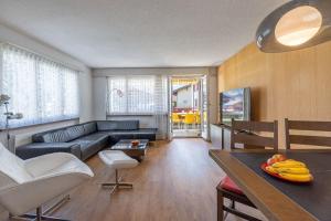 a living room with a couch and a table at With Mountain View & Balcony Kitchen Parking in Kandersteg
