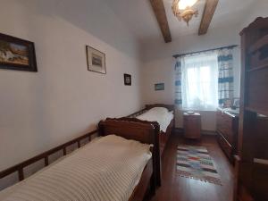 a bedroom with two beds and a dresser and a window at Siske malom in Balatonfüred