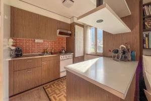 a kitchen with wooden cabinets and a white counter top at With Mountain View & Balcony Kitchen Parking in Kandersteg +17 photos