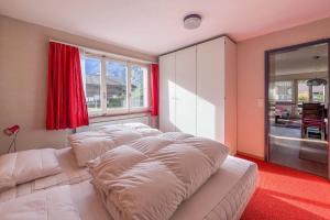 a living room with a white couch and a window at With Mountain View & Balcony Kitchen Parking in Kandersteg