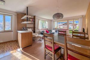 a kitchen with a table and a dining room at With Mountain View & Balcony Kitchen Parking in Kandersteg