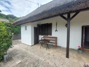 a small white house with a bench on a patio at Siske malom in Balatonfüred +1 photo