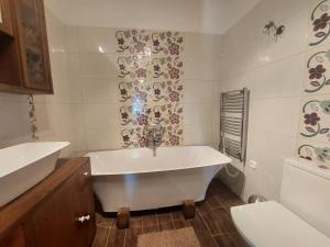 a white bathroom with a tub and a toilet at Siske malom in Balatonfüred