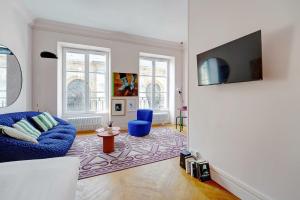 a living room with a blue couch and a tv at Spacious Studio - 2P 43m² - Montorgueil Louvre in Paris +4 photos