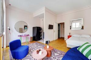 a living room with a bed and a blue chair at Spacious Studio - 2P 43m² - Montorgueil Louvre in Paris