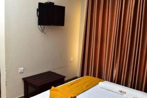 a bedroom with a bed and a television on the wall at Polka GuestHouse in Tshabong +5 photos