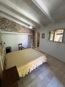 a bedroom with a bed and a stone wall at Posto Cantoro in Marina di Pescoluse