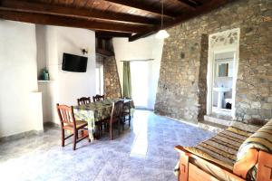 a dining room with a table and a stone wall at Posto Cantoro in Marina di Pescoluse