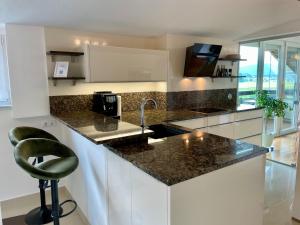 a kitchen with a counter with a sink and a chair at Moderne Oase mit Panorama-Blick in Villach