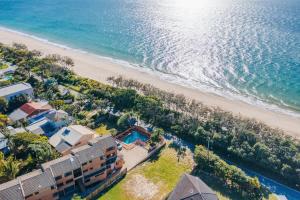 WoorimWoorim Waves - Beachfront Comforts with Shared Pool的海滩与房屋和海洋的鸟瞰图