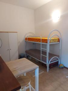 a room with two bunk beds and a table at Appartamento nel centro di porto azzurro in Porto Azzurro