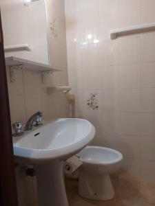 a white bathroom with a sink and a toilet at Appartamento nel centro di porto azzurro in Porto Azzurro