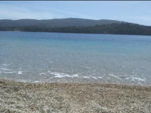 a large body of water with a rocky beach at Appartamento nel centro di porto azzurro in Porto Azzurro