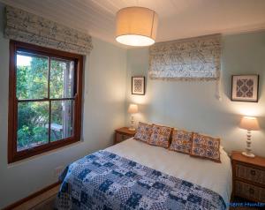 Un dormitorio con una cama azul y blanca y una ventana. en Shutters on Hilltop, Scarborough, en Scarborough 46 fotos más