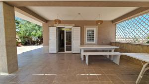a patio with a bench and a table and a door at Casa Marispica in Ispica