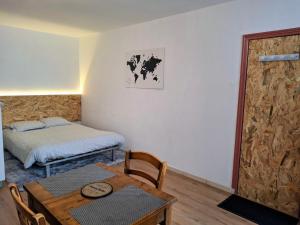 a room with a table and a bed and a room with a table and chairs at Appartement centre-ville in Aurillac