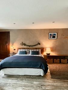 a bedroom with a large bed and a wall at Maison de la montagne - Chambres & Relax in Arvier
