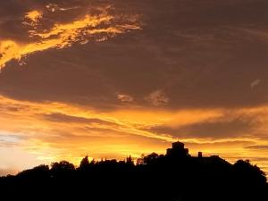 una sagoma di un edificio con un tramonto sullo sfondo di IL GIARDINO FIORITO Luxury Guest House B & B a Cesena