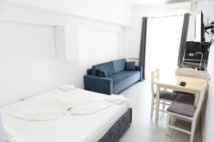 Un dormitorio con una cama y una silla azul. en Apartaments Tafi Holiday, en Shëngjin 12 fotos más