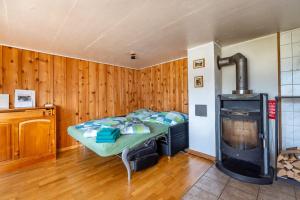 a bedroom with a bed and a woodburning stove at Cozy Studio With Terrace Bbq Mountain View in Ober Stafel