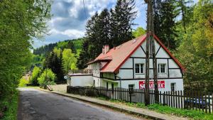 a white house with a red roof next to a road at Pensjonat Sokolec in Sokolec +18 photos