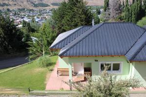 a house with a black roof with a bench at Esquel Apart Chalet in Esquel