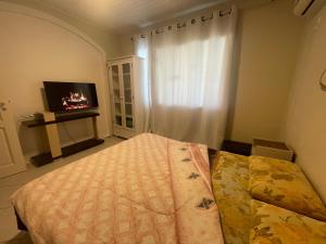 a bedroom with a bed and a tv and a window at A Pérola do Gravatá in Navegantes