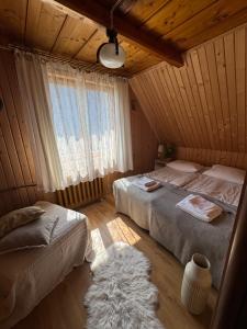 a bedroom with two beds and a window at Cisza pod Tatrami in Bukowina Tatrzańska