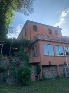 a large pink house with a stone wall at Logis Hotel-restaurant Les Glycines in Arles-sur-Tech