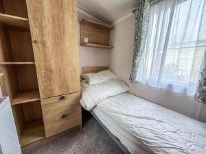ヘムズビーにあるStunning Caravan With Side Decking Just A Short Walk To Hembsy Beach Ref 00069Baのベッドと窓のある小さな寝室