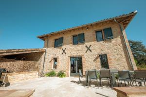 a stone building with chairs in front of it at Gîte Le Rivalou - Grazac - Tarn in Grazac