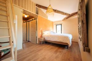 a bedroom with a bed in a room with wooden floors at Gîte Le Rivalou - Grazac - Tarn in Grazac +14 photos