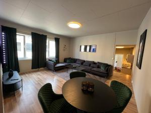 a living room with a couch and a table and chairs at Notodden Sentrum Apartment NO 12 in Notodden