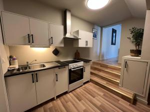 a kitchen with white cabinets and a wooden floor at Notodden Sentrum Apartment NO 12 in Notodden