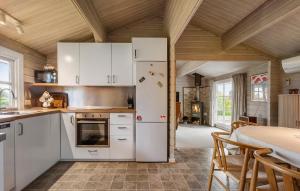 een keuken met een witte koelkast en een tafel bij Holiday Home Teglbakken Xii in Egernsund