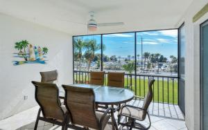 a dining room with a table and chairs and a balcony at Crescent Royale Condominiums 201 in Siesta Key