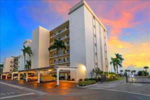 a large white building with a car parked in a parking lot at Crescent Royale Condominiums 201 in Siesta Key