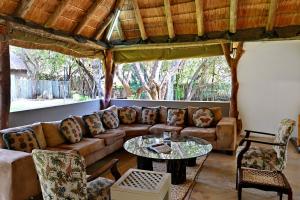 马加利斯堡Warthogs Bush Lodge的客厅里有一张沙发和一张桌子。