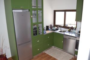 a kitchen with green cabinets and a white refrigerator at Quinta do Santo no Douro - Casa T2 in Alcarias