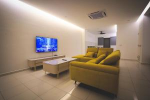 a living room with a couch and a tv at HM Residence 11pax Setia City Convention in Shah Alam