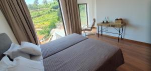 a bedroom with a bed and a large window at Quinta do Santo no Douro - Casa T2 in Alcarias +30 photos