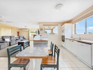 贝尔拉拉Coastal Comforts with Pumicestone Passage Views的配有桌椅的厨房和客厅