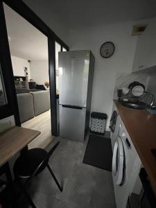 a kitchen with a stainless steel refrigerator in a room at Appartement T2 Le galant vert avec clim et parking in Aucamville +10 photos