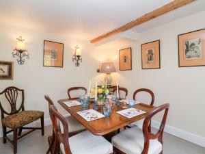 a dining room with a wooden table and chairs at Magdalen Cottage in Banbury