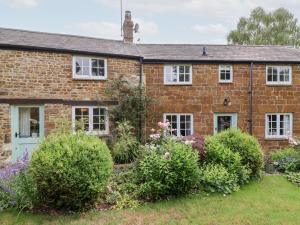 an old brick house with bushes in front of it at Magdalen Cottage in Banbury